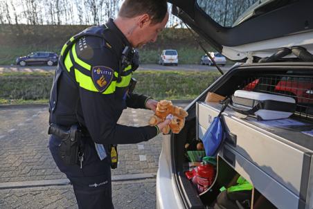 Kinderen krijgen een troostbeer van politie na aanrijding aan de Prof. Lorentzweg Waalwijk