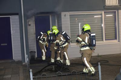 Brandweer zaagt voordeur open bij woningbrand Van Wielesteinstraat: Politie onderzoekt verdachte situatie