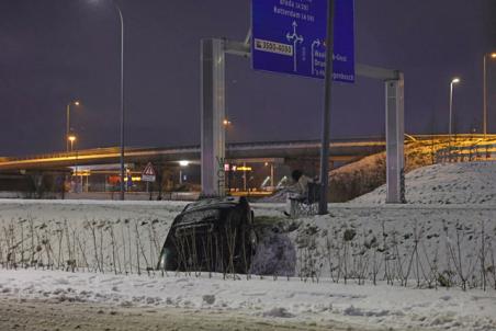 Automobilist belandt in sloot door sneeuw en wacht rustig af met hamburger en stoeltje in Waalwijk