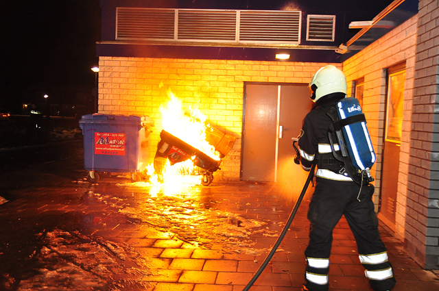 Container staat in brand tegen winkelpand aan de Prof. De Savornin Lohmanpark Waalwijk