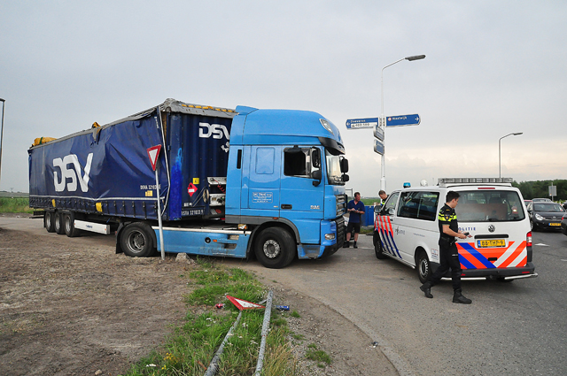 Vrachtwagen klem onder viaduct Waalwijk; brug en wagen beschadigd