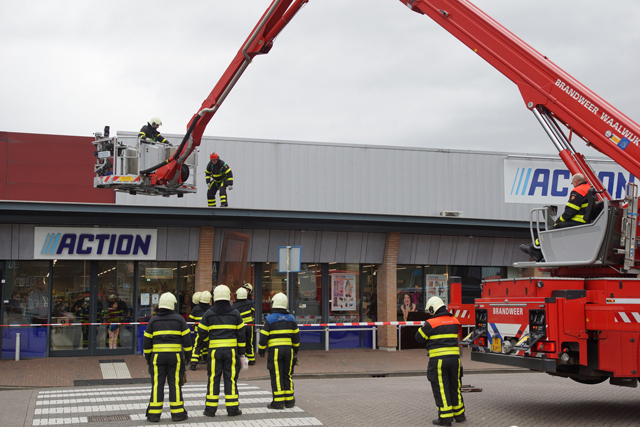 Brandweer haalt losse dakplaten van dak Action Waalwijk