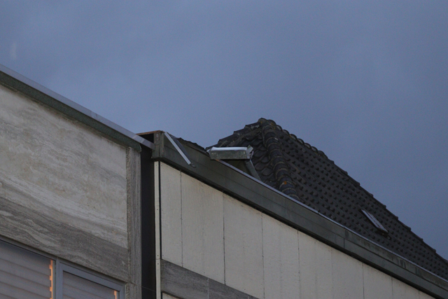 Gedeelte van dak winkel raakt los door wind aan de Stationsstraat Waalwijk