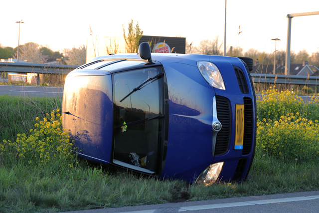 Auto op zijn kant op de A59 (Maasroute) Waalwijk
