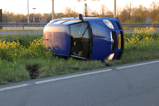 Auto op zijn kant op de A59 (Maasroute) Waalwijk
