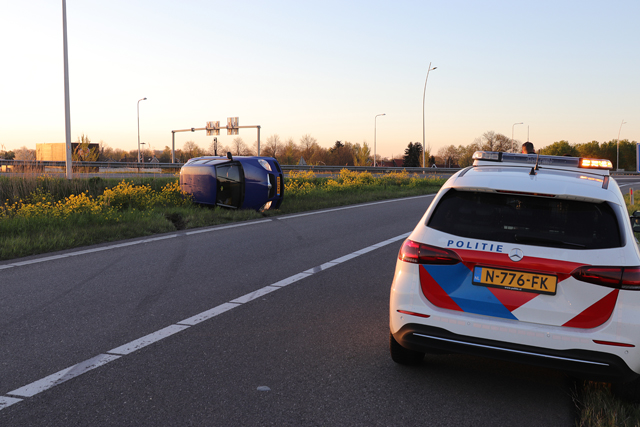 Auto op zijn kant op de A59 (Maasroute) Waalwijk