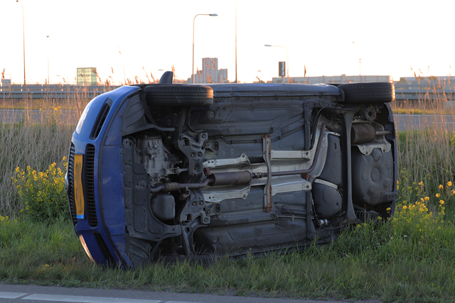 Auto op zijn kant op de A59 (Maasroute) Waalwijk