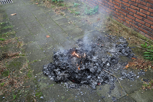 Berg papier in brand in brandgang aan de Drogerij Waalwijk