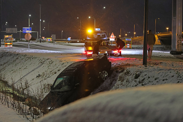 Automobilist belandt in sloot door sneeuw en wacht rustig af met hamburger en stoeltje in Waalwijk