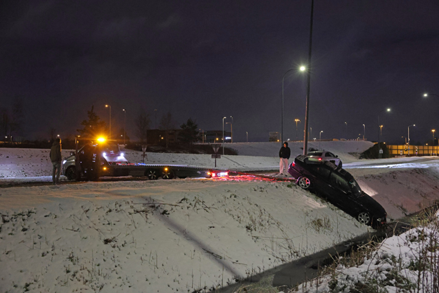 Automobilist belandt in sloot door sneeuw en wacht rustig af met hamburger en stoeltje in Waalwijk