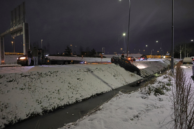 Automobilist belandt in sloot door sneeuw en wacht rustig af met hamburger en stoeltje in Waalwijk